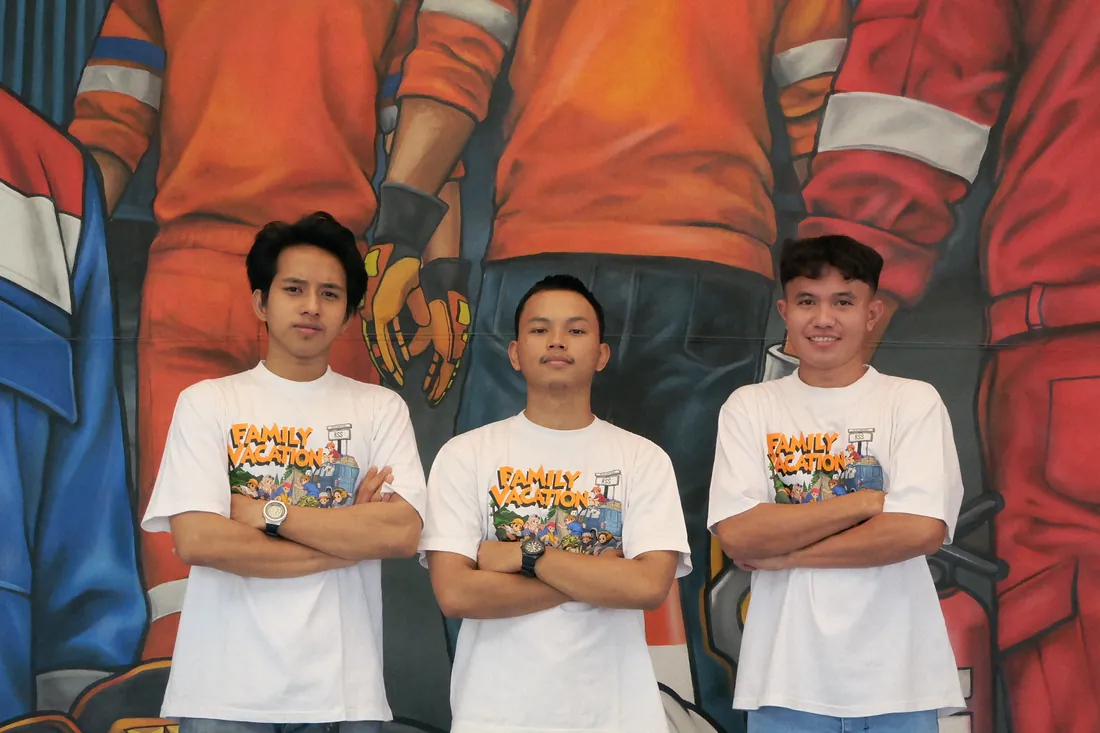 Tiga anggota tim Rezeki Shoes Safety berfoto di depan mural